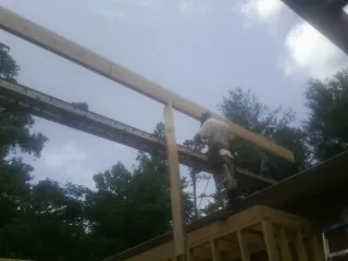 Carpenter setting a ridge beam over a new addition frame — Ice Dam Removal by Roofing Brothers in Nunn