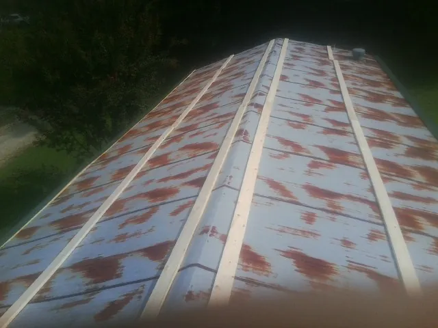 Rusted metal roof panels with new wood purlins before replacement — Storm Damage Roof Repair in Nunn by Roofing Brothers