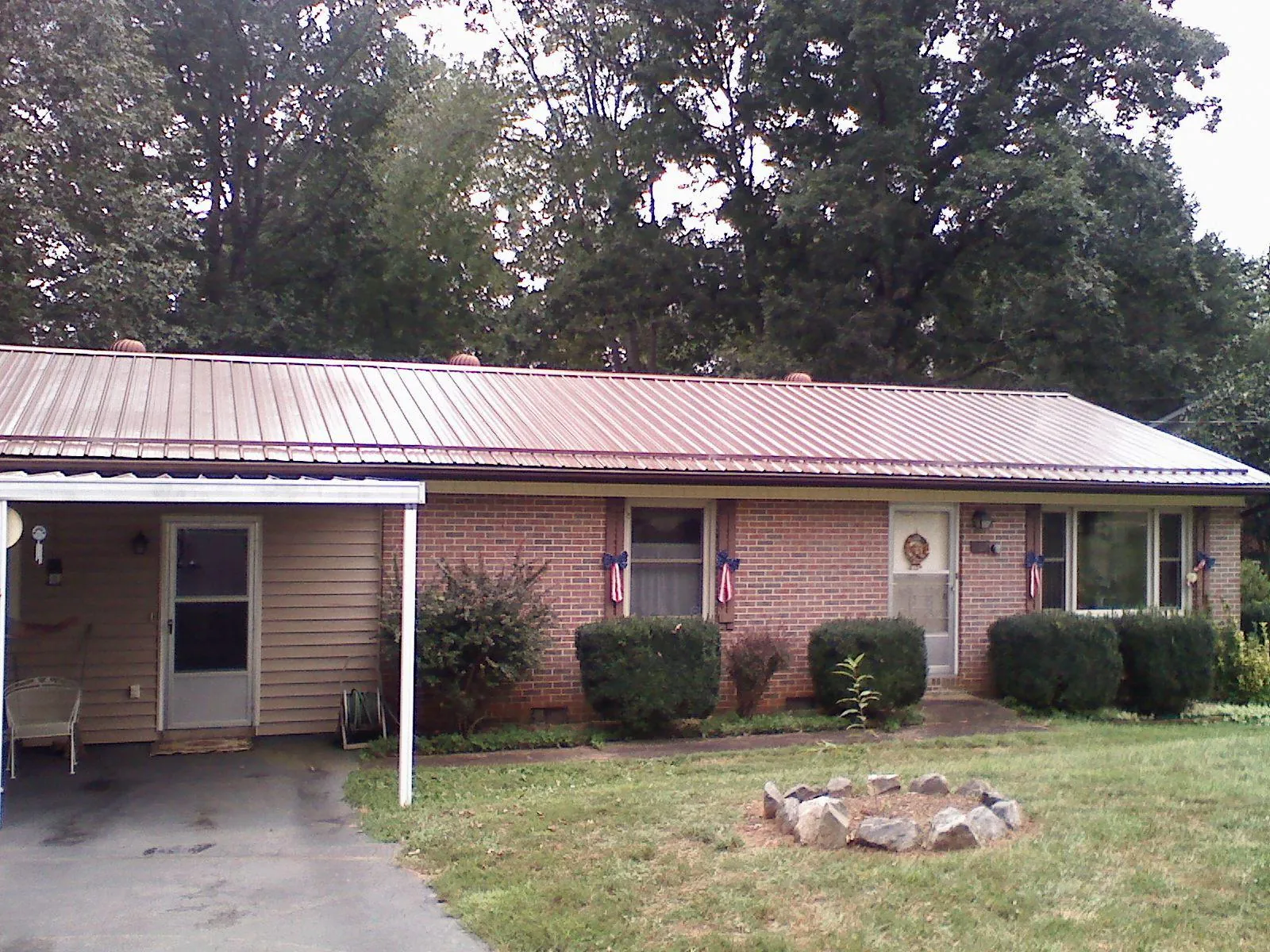 Bronze metal roof and carport on a brick ranch home — Roof Repair work by our crew in Nunn
